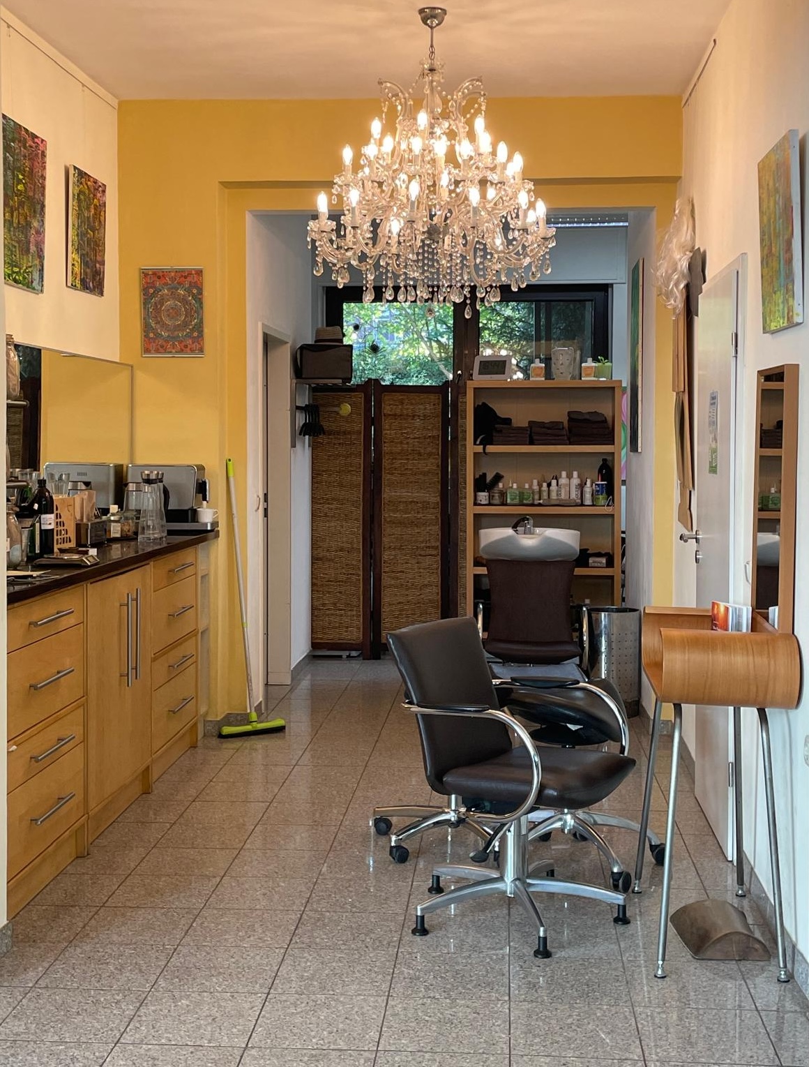 Innenraum der Haargalerie Aachen mit Friseurplätzen, Waschliege und Kristalllüster