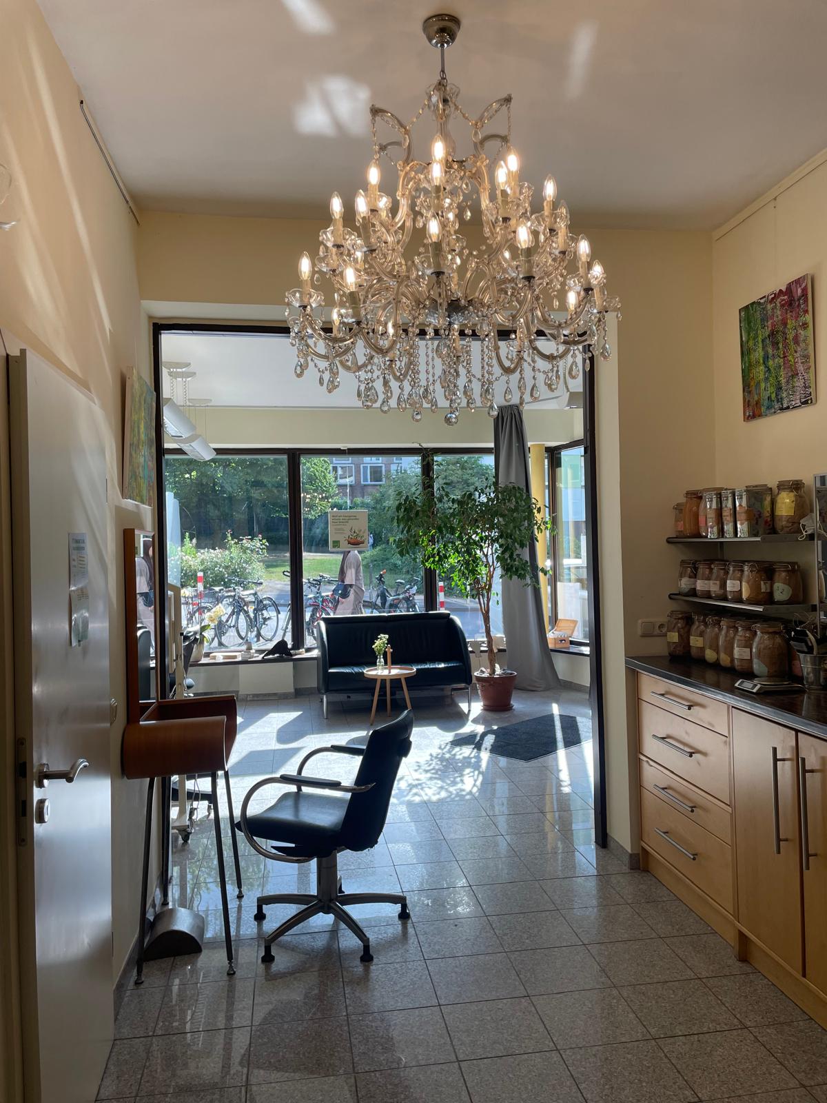 Sonnendurchflutetes Entree der Haargalerie mit Wartebereich und Pflanzenfarben-Gläsern